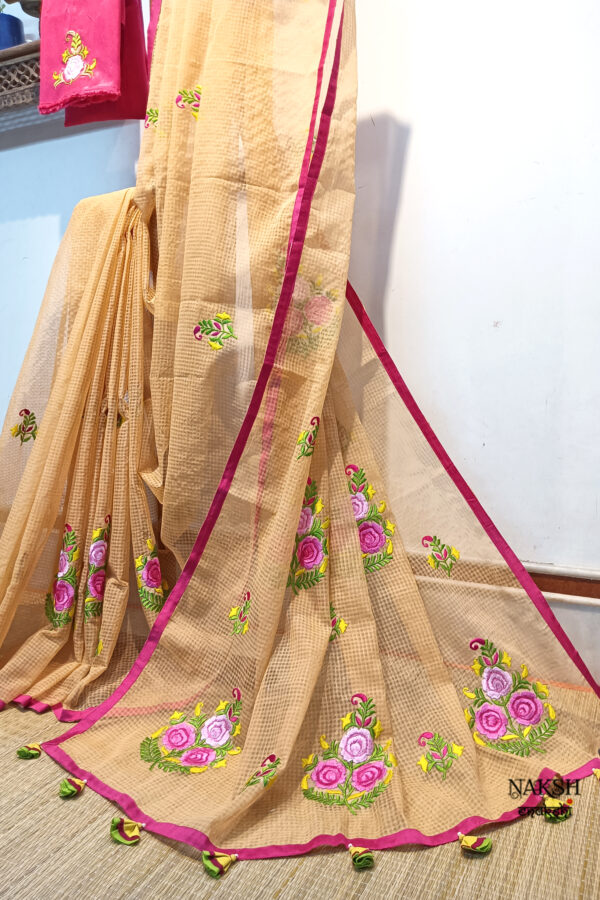 Exquisite embroidery work in floral design has been neatly done on a sandalwood color Resham check saree.