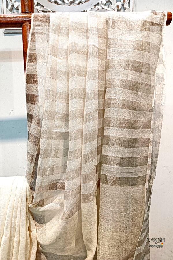 zari stripes white or off white linen saree organic linen saree with blouse piece. Step into elegance with our sophisticated tissue linen sarees, adorned in refreshing pastel shade of mint green that exude timeless charm. Crafted with airy, breathable linen, this saree ensure comfort while making a striking statement with their unique silver zari stripes. Perfect for any occasion, from casual gatherings to formal events, these sarees are versatile and effortlessly stylish. this saree comes with a running blouse piece, completing the ensemble with grace and finesse. Elevate your wardrobe with these exquisite pieces that blend luxury with comfort seamlessly.