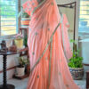 Full length peach blossom pure cotton handloom saree with all over teal embroidery motifs gold scallop border and white tassels displayed on mannequin by Naksh by Enakshi