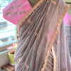 Close up of smoky mauve pure cotton handloom fabric with gold pink embroidery motif and decorative scallop border detail