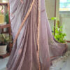 Close up of smoky mauve pure cotton handloom fabric with gold pink embroidery motif and decorative scallop border detail