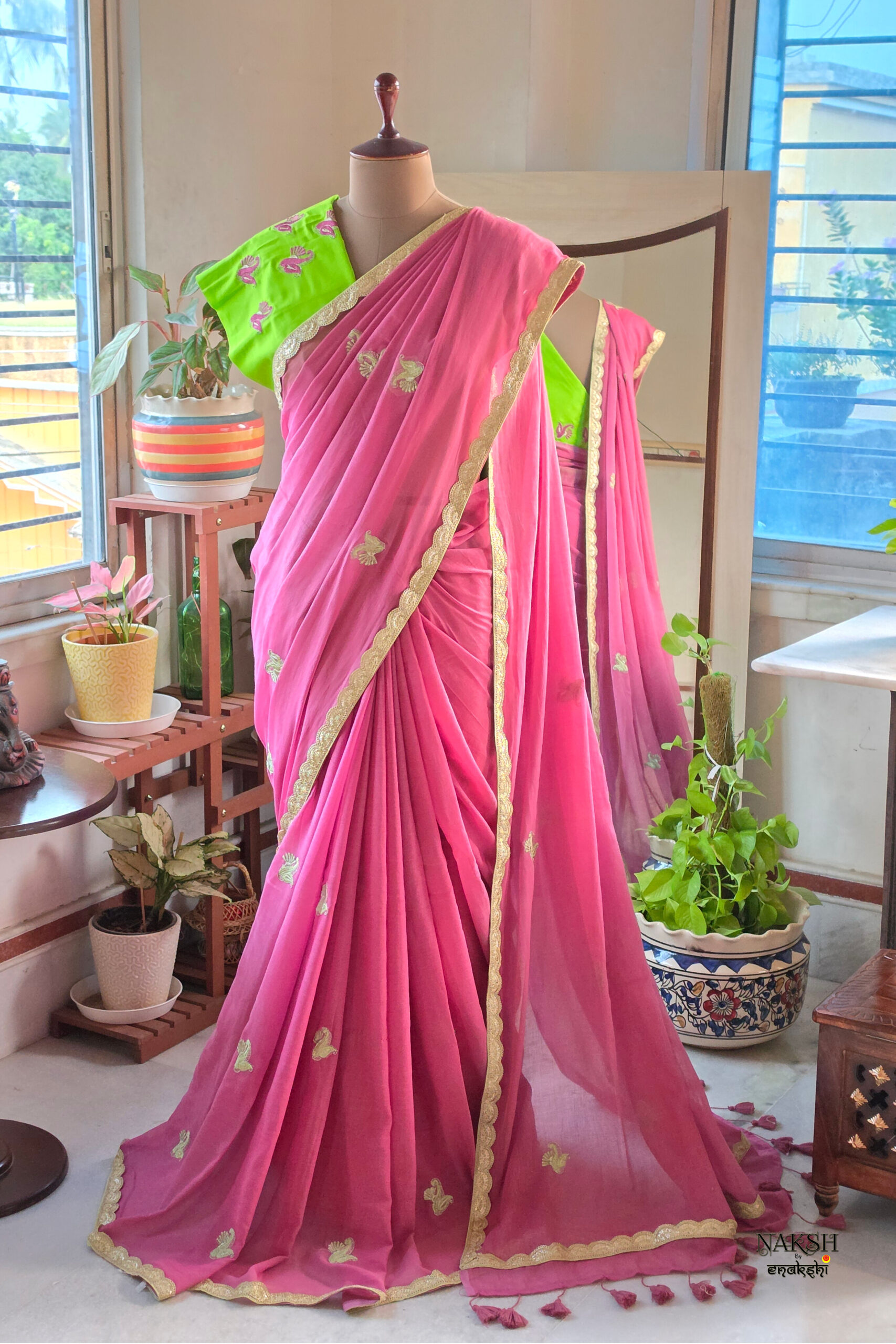 Full length rose petal dusty pink pure cotton handloom saree with all over gold embroidery motifs gold scallop border contrast lime green blouse and pink tassels displayed on mannequin by Naksh by Enakshi